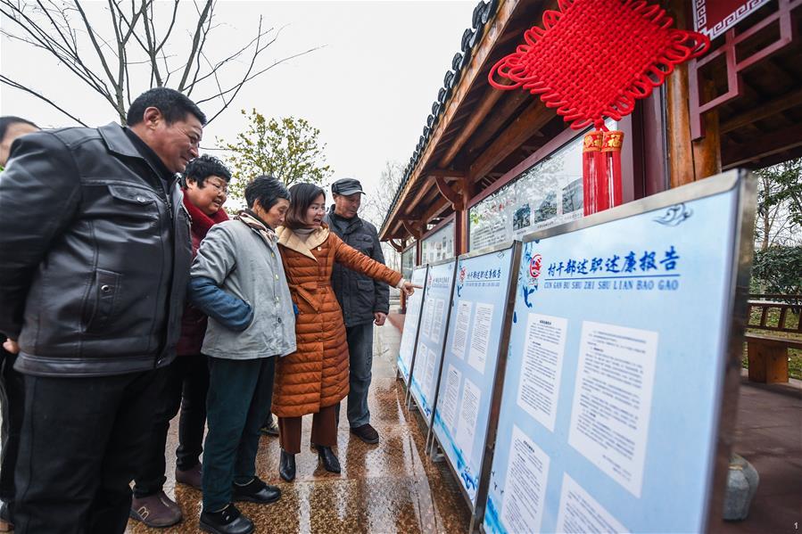 浙江省长兴县虹星桥镇港口村党总支委员许方方（右二）向村民介绍2018年度村干部述职述廉情况（2019年1月15日摄）。虹星桥镇港口村将村班子成员2018年度个人述职述廉报告张贴出来，接受村民监督。新华社记者 徐昱 摄